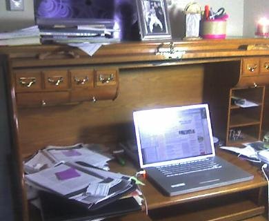 Desk with laptop and lots of papers